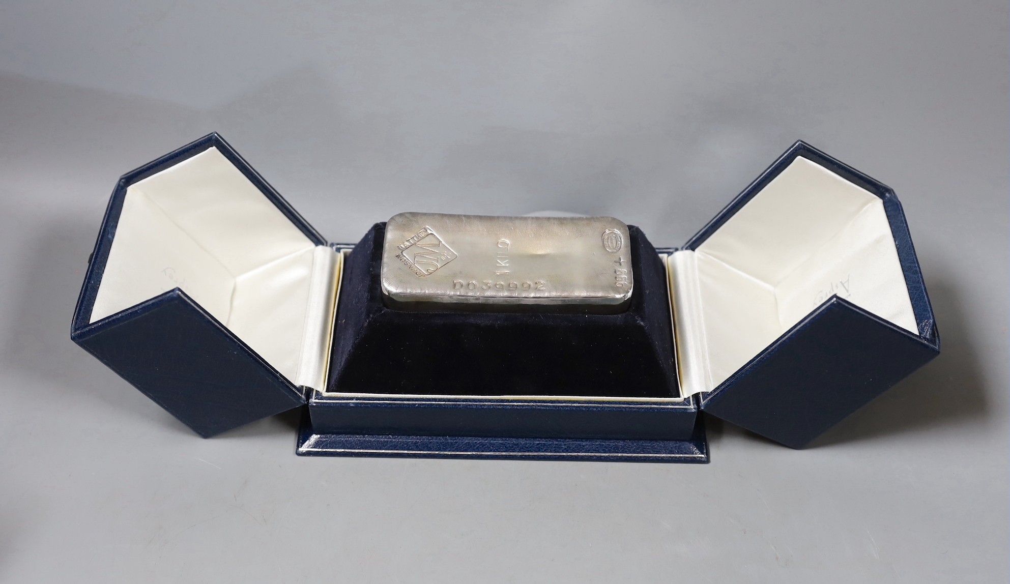 A modern Johnson & Matthey silver 1kg ingot, 11.3cm, with engraved presentation inscription, in Asprey fitted case.